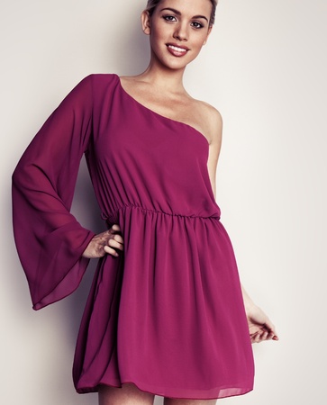 Young teen woman wearing a purple dress posing isolated on a white backgroundの写真素材
