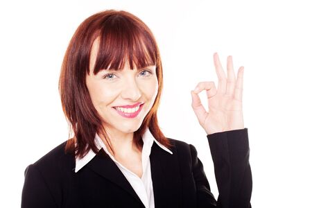 Attractive happy redhead woman giving a gesture of perfection with her fingers isolated on whiteの写真素材