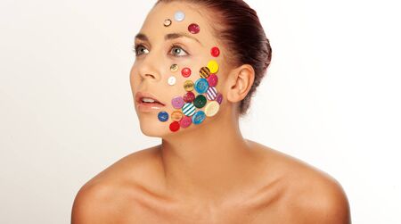 Attractive woman, with various buttons on her face, looking upの写真素材