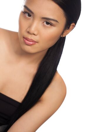 Cropped portrait of a seductive beautiful Asian woman looking down at the camera isolated on whiteの写真素材