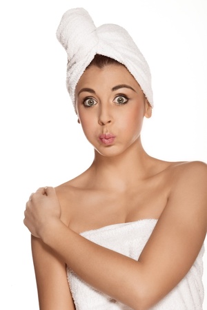 Pretty woman with a towel around her head against the white backgroundの写真素材