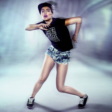 Young urban woman dancing, club style surroundingsの写真素材
