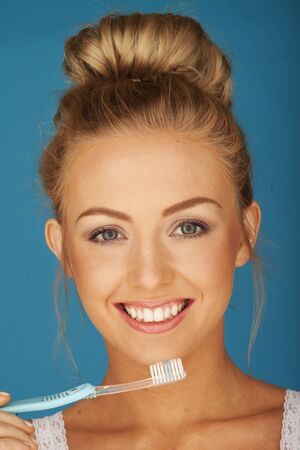 Sexy woman on blue brushing her teeth の写真素材