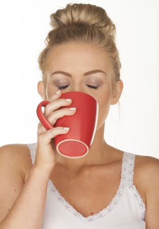 Sexy woman on white drinking from red cup の写真素材