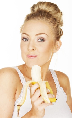 Sexy woman on white eating banana の写真素材