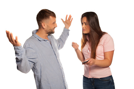 Young couple having an argument with an irritated woman and the man in a defensive attitudeの写真素材