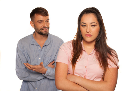 Young couple having an argument with man discussing or giving explanations and the woman sad or upsetの写真素材