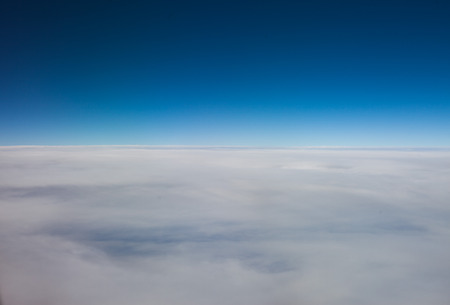 Flying above a layer of high altitude cirrostratus cloud forming a hazy white blanket in the blue...