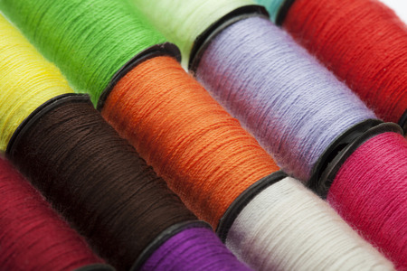 Background made of a close-up of many colorful sewing threads