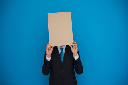 Businessman holding blank poster on blueの写真素材