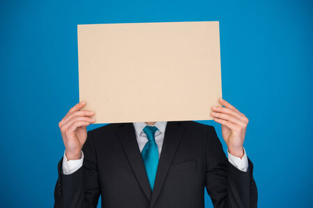 handsome Businessman holding blank poster on blueの写真素材