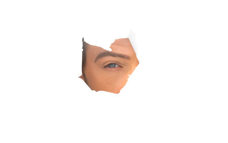 eye of the businessman on white paper holeの写真素材