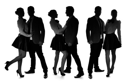 Three silhouettes of a romantic loving couple striking different intimate poses with the man wearing a suit and woman in an elegant miniskirt and stilettos, on whiteの写真素材