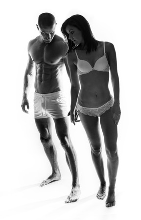 Two Young Couple on Sexy Underwear Showing Perfect Body Figures, Isolated on White.の写真素材
