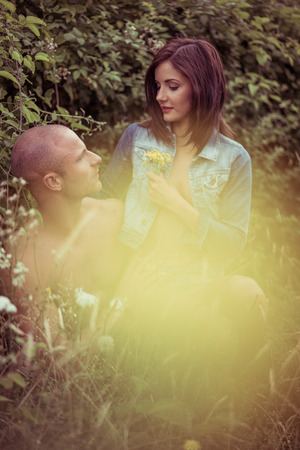 Young Lovers Dating on Bush Portrait with Light Yellow Flare. Emphasizing Romance is Everywhereの写真素材