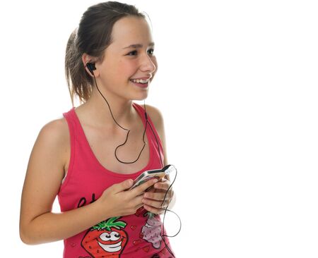 Happy young girl enjoying her music smiling with pleasure as she listens to tunes downloaded on an mp3 storage device, on whiteの写真素材