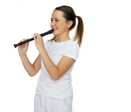 Happy girl playing the flute on white backgroundの写真素材