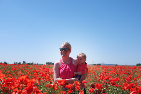 mom and little baby on the poppy fields posing for the pictureの写真素材