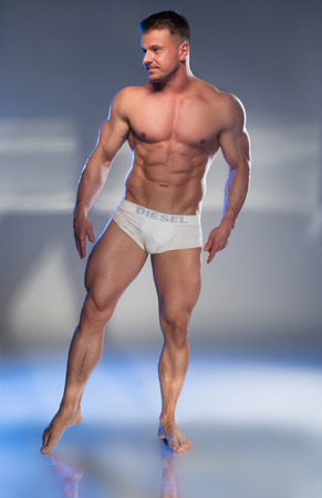 Muscular Man in White Boxer Shorts on grey backgroundの写真素材