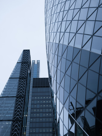 Perspective and underside angle view to textured background of contemporary glass building skyscrapers in Londonの写真素材