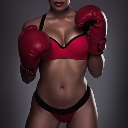 Young beautiful woman during fitness and boxing body photo red glovesの写真素材