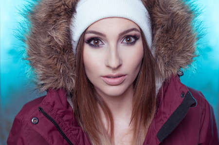 closeup portrait of woman wearing winter jacket and hat with fresh face