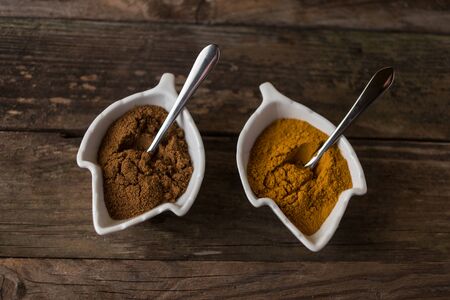 curcuma and curry spices on wooden table with the spoons ready to serve