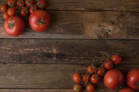 Fresh, ripe tomatoes on an old wooden board table?の写真素材