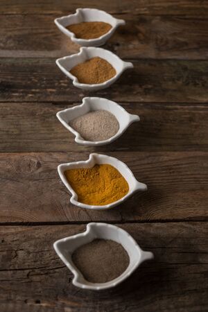 spices. few kinds of pepper , curryy and other herbs on the wooden tableの写真素材