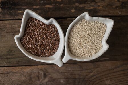 sesame and  linseed in the bowls on the wooden tableの写真素材