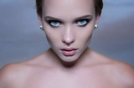 pretty woman with blue eyes and dark hair on blueの写真素材