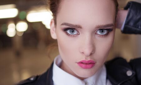 pretty woman close-up with blue eyes and full lips wearing leather jacketの写真素材