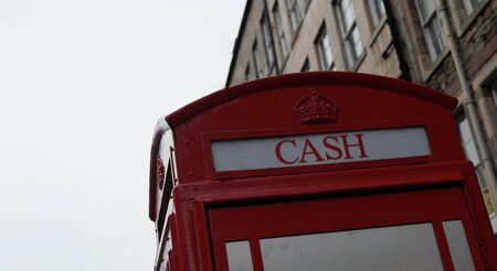 Top of the British Phone Booth with writing "cash" in Edinburgh, Scotlandのeditorial素材