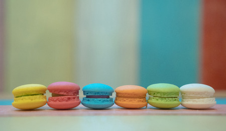 Multicolored macaroons on white wooden background. . Macaron or Macaroon is sweet meringue-based confectionの写真素材