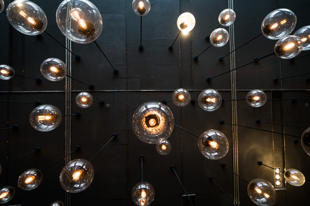 Bottom view of light bulbs background over dark wallの写真素材