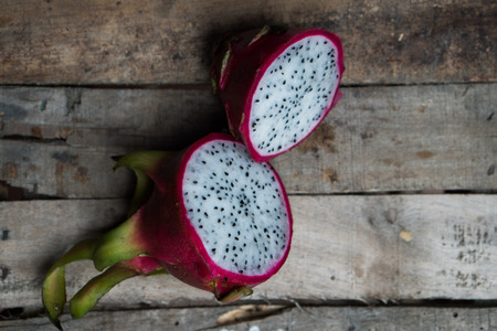 Closeup top view of dragon fruit isolated on old wooden table backgroundの写真素材