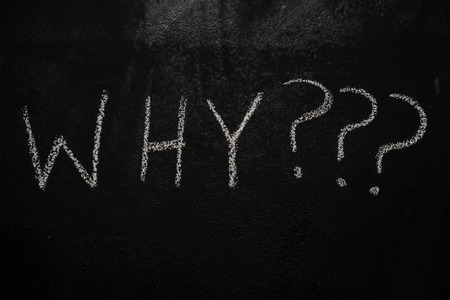 Why with question marks drawn with white chalk on blackboardの写真素材