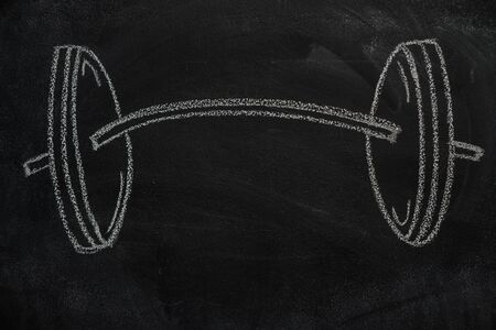 Barbell drawn with white chalk on blackboardの写真素材
