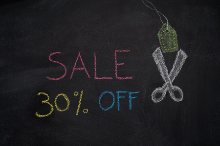 Sale 30% off. Sale and discount price sign with scissors cutting price tag drawn with chalk on blackboardの写真素材