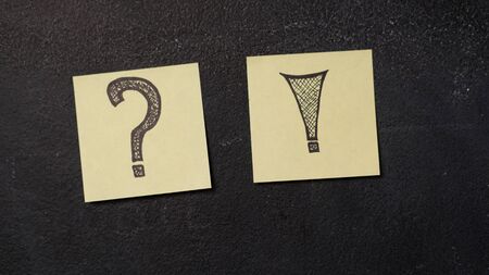 Sticky notes with question and exclamation mark on the blackboard