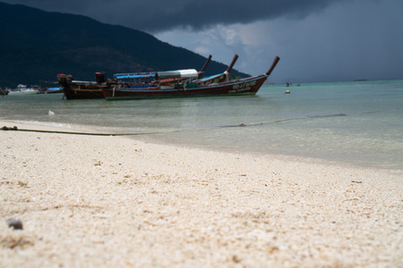 Sandy beach and sea with boats over cloudy sky. Koh Lipe island in Thailandの写真素材