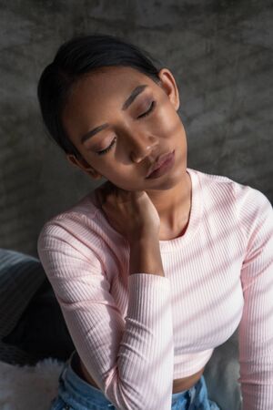 Portrait of young woman at home suffering from neck pain. Health care and medical conceptの写真素材