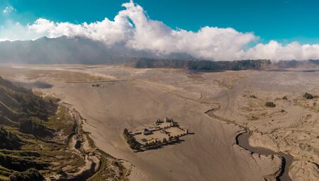 Cinematic shot aerial view of Pura Luhur Poten hindu temple near Mount Bromo volcano in East Java, Indonesiaの写真素材