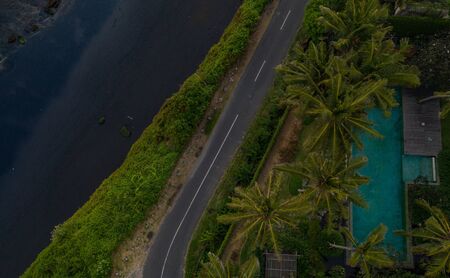 Aerial drone view of tropical island with black beach in Bali, Indonesia