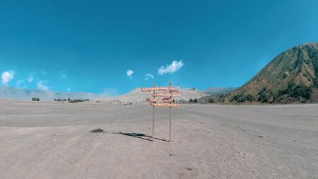 Wood sign and beautiful Mount Bromo volcano with desert in East Java, Indonesiaの写真素材