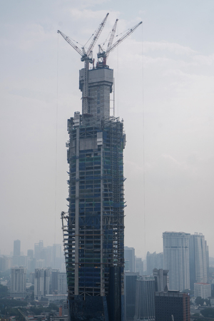 Aerial drone view of unfinished skyscraper over cloudy sky in Kuala Lumpur, Malaysiaのeditorial素材