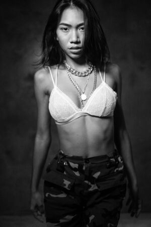 Young beautiful fashion Asian girl dancer wearing stylish clothes posing in studio - black and white photoの写真素材