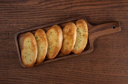 Toasted baguette slices isolated on rustic wooden kitchen tableの写真素材
