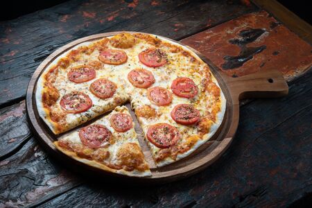 Fresh tasty pizza Margarita isolated on rustic wooden backgroundの写真素材