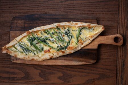 Turkish pide with morning glory and cheese isolated on rustic wooden tableの写真素材